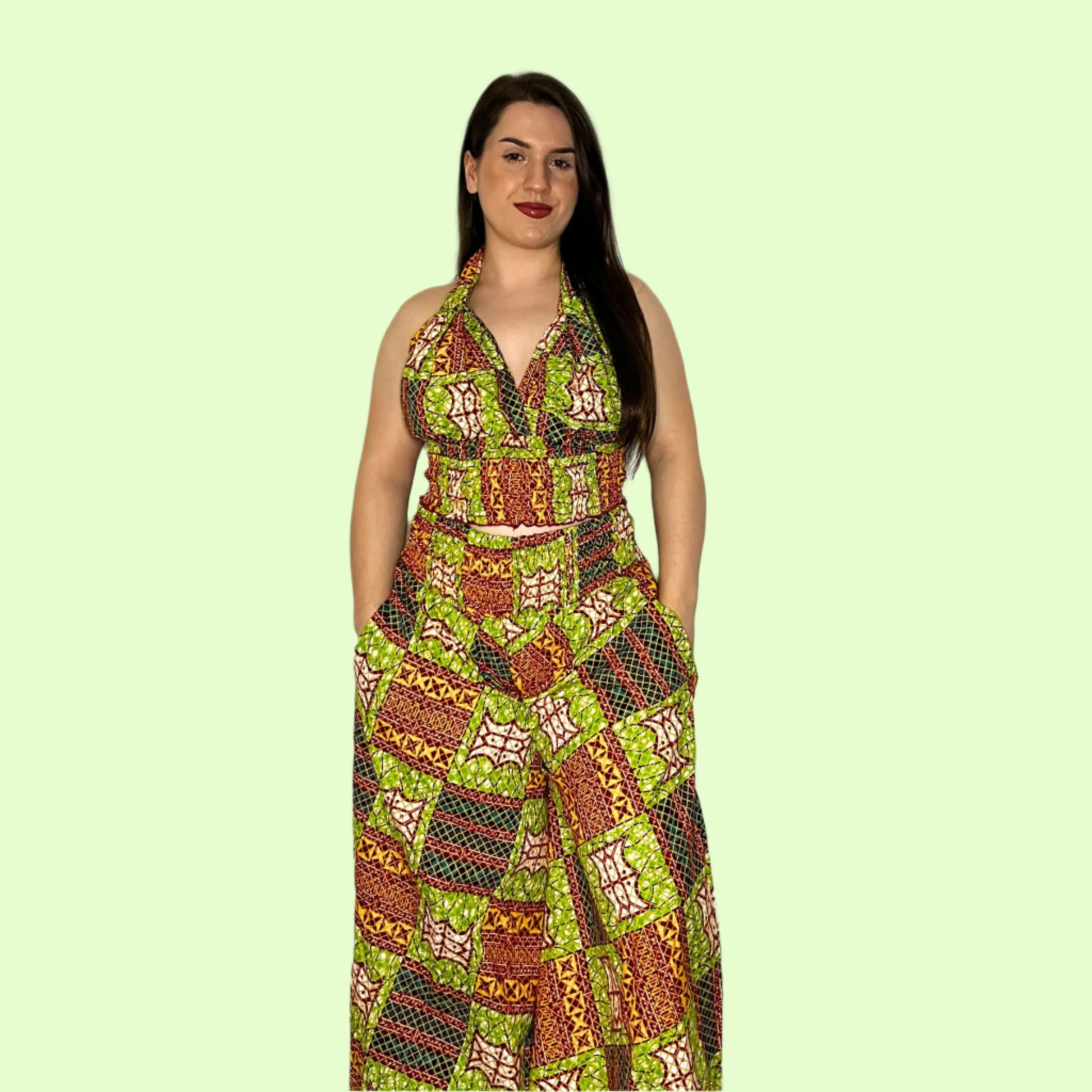 A model wearing a green, red, and yellow geometric patterned halter neck top and wide-leg culotte set.
