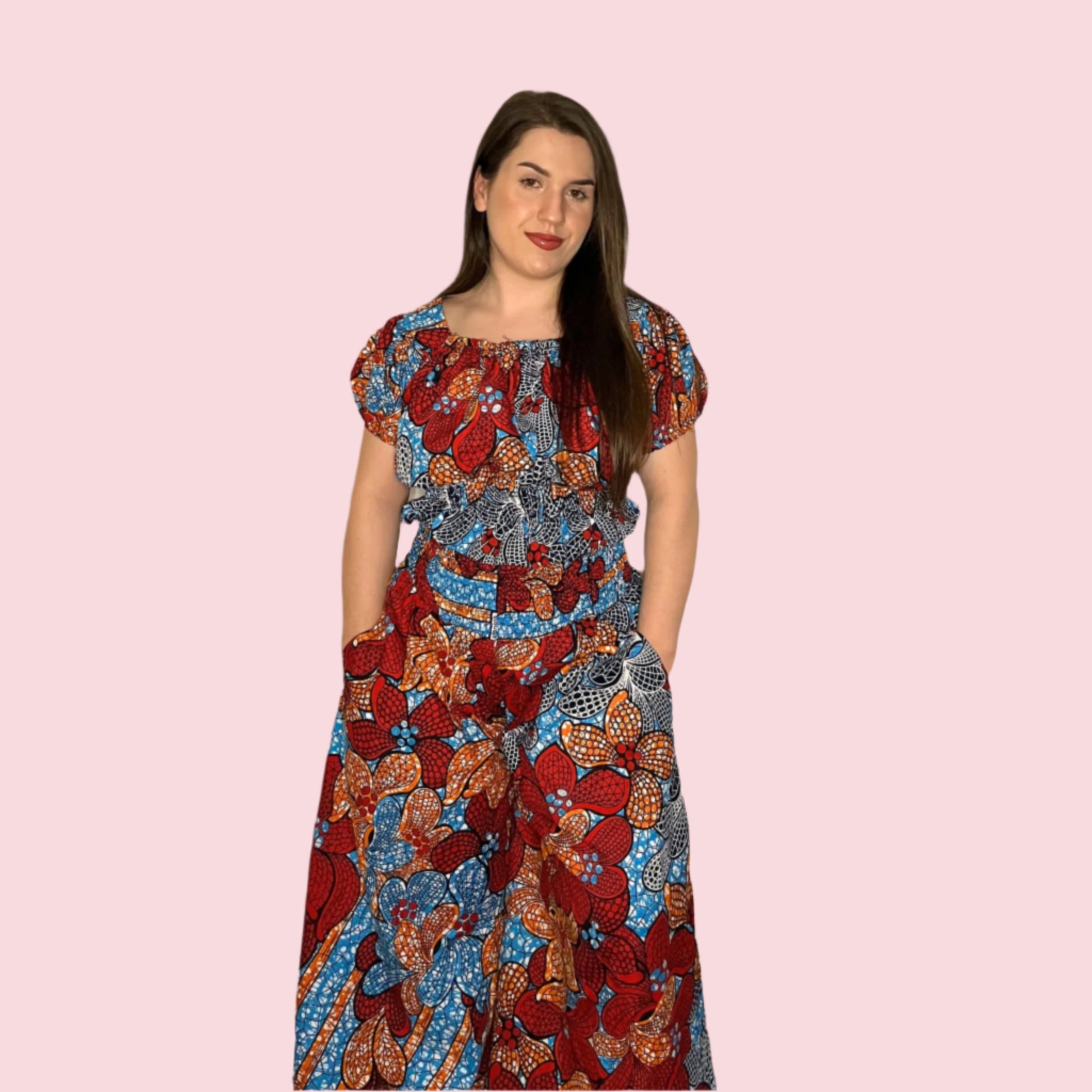 A model wearing a multicolored shirred waist top and wide-leg culottes, in a vibrant floral and geometric pattern.